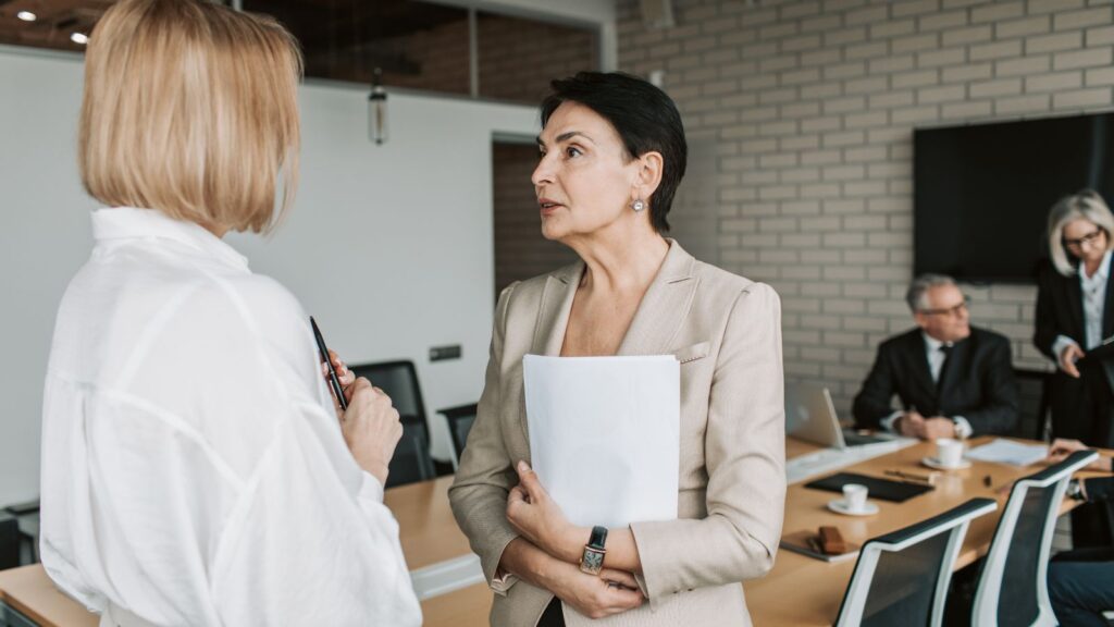 Kobiety omawiają prezentacje, którą przygotowały na spotkanie biznesowe.