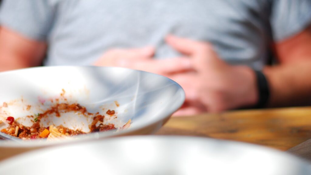 Mężczyzna odpoczywa po obfitym jedzeniu w domu.