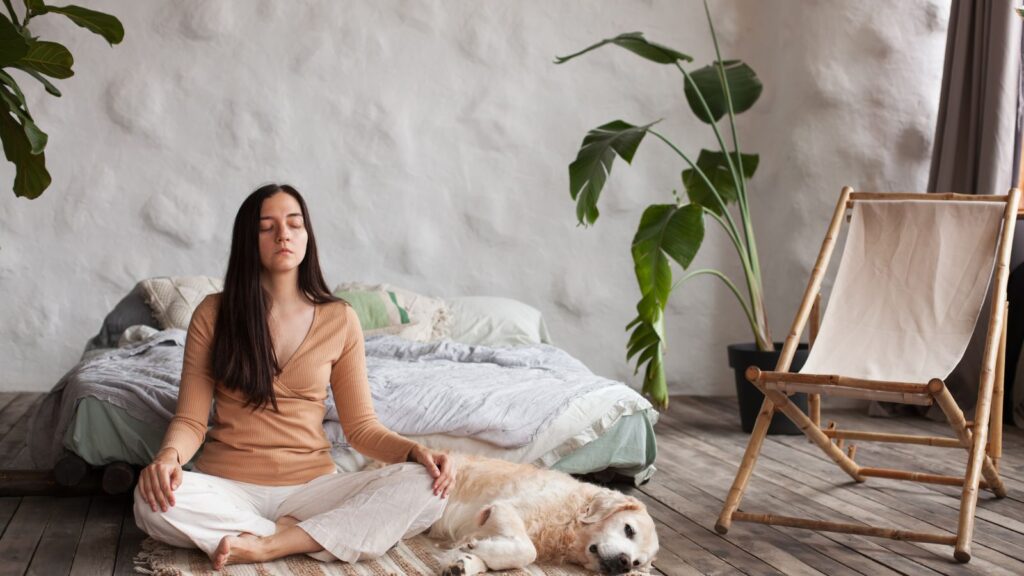 Młoda kobieta relaksuje się z psem u boku w domu.