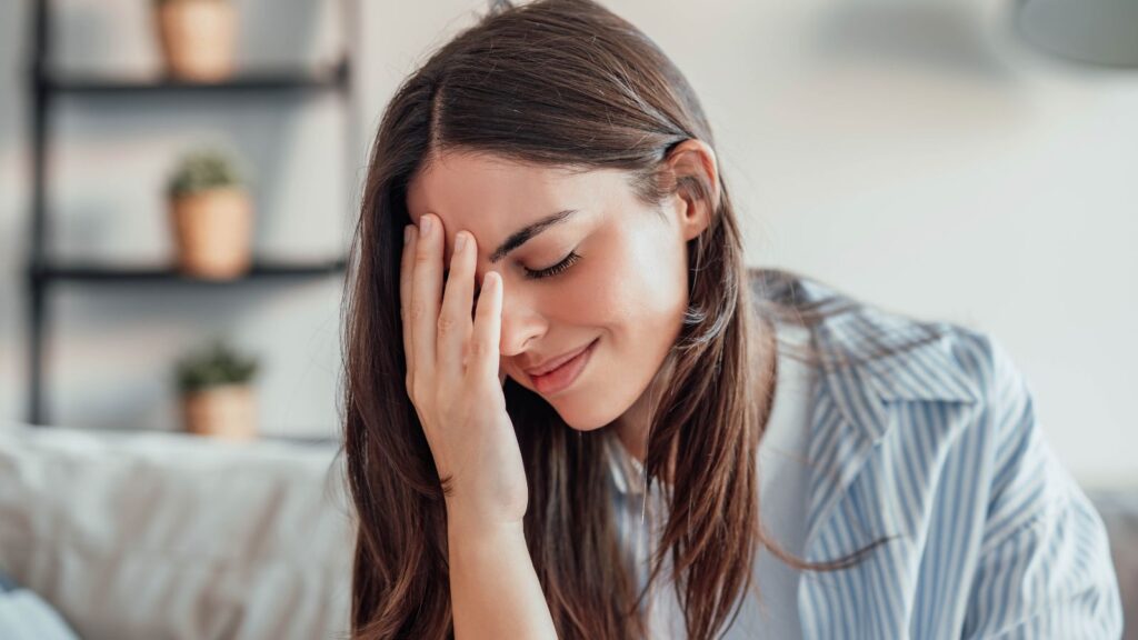 Kobieta trzyma się za głowę z powodu stresu od samego rana.