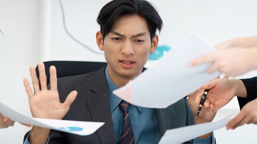 Zmęczony mężczyzna próbując nadążyć za obowiązkami.